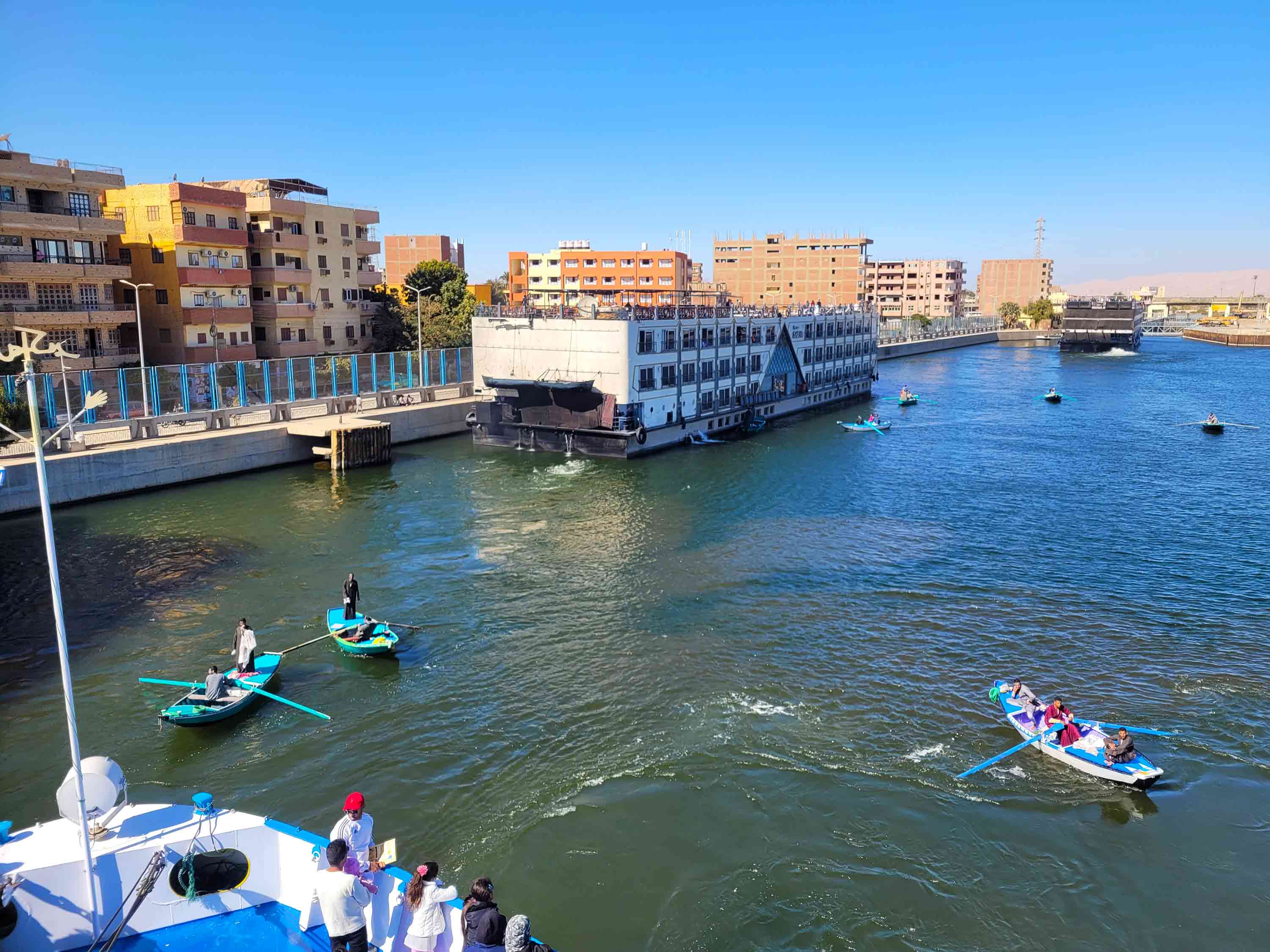 Nile cruise ships wait to go through the Esna Lock as local Egyptians sell souvenirs from rowboats