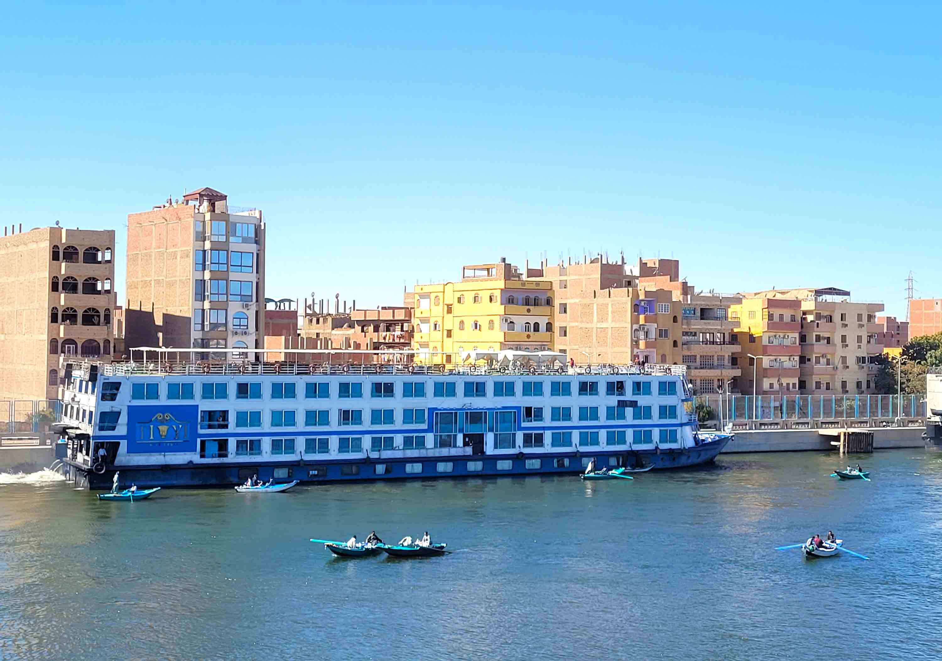A cruise ship docks along the banks of the Nile while waiting to pass through Egypt’s Esna Lock