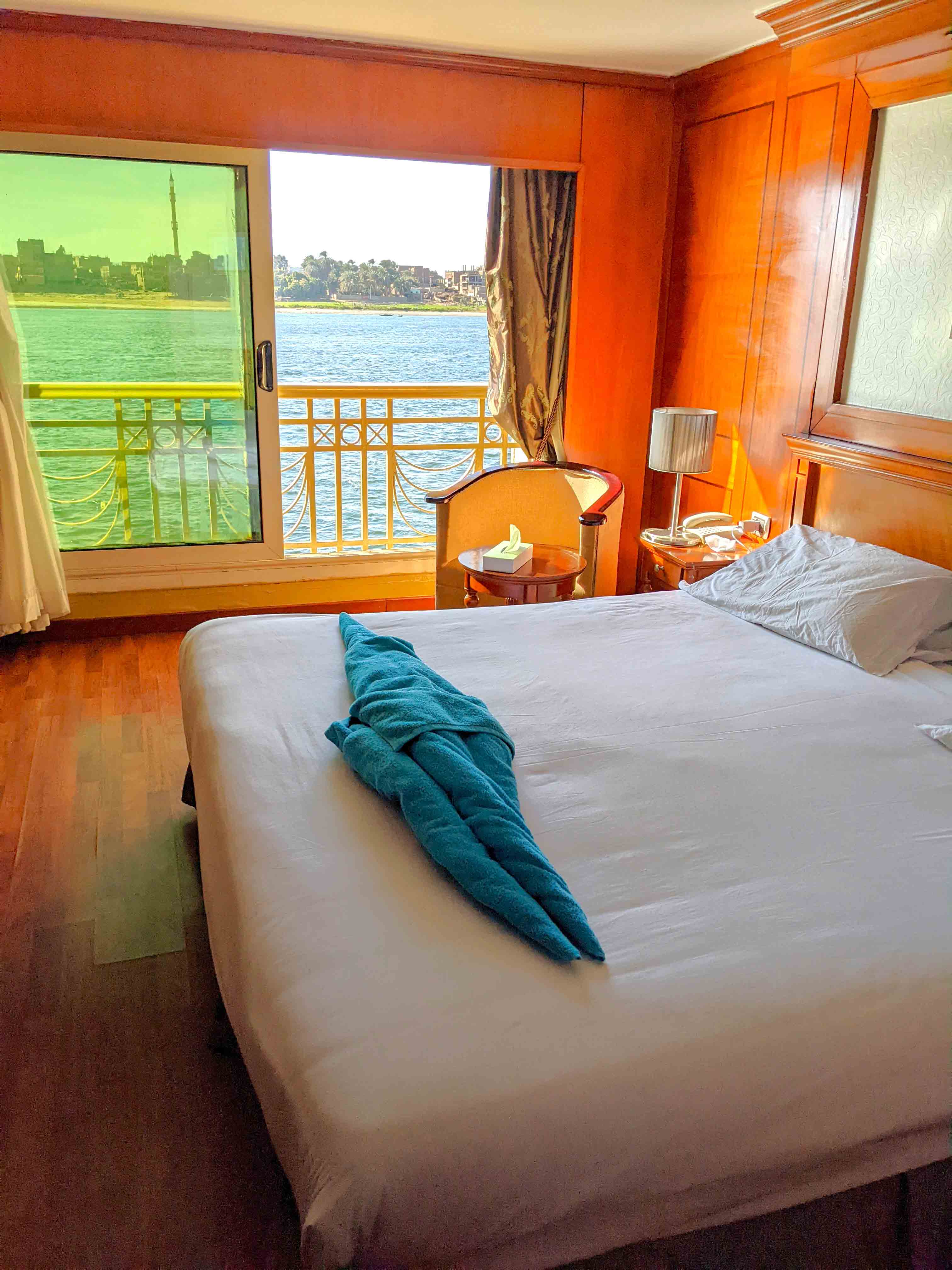 River bank scenery streams by through the window of a berth on a Nile cruise ship