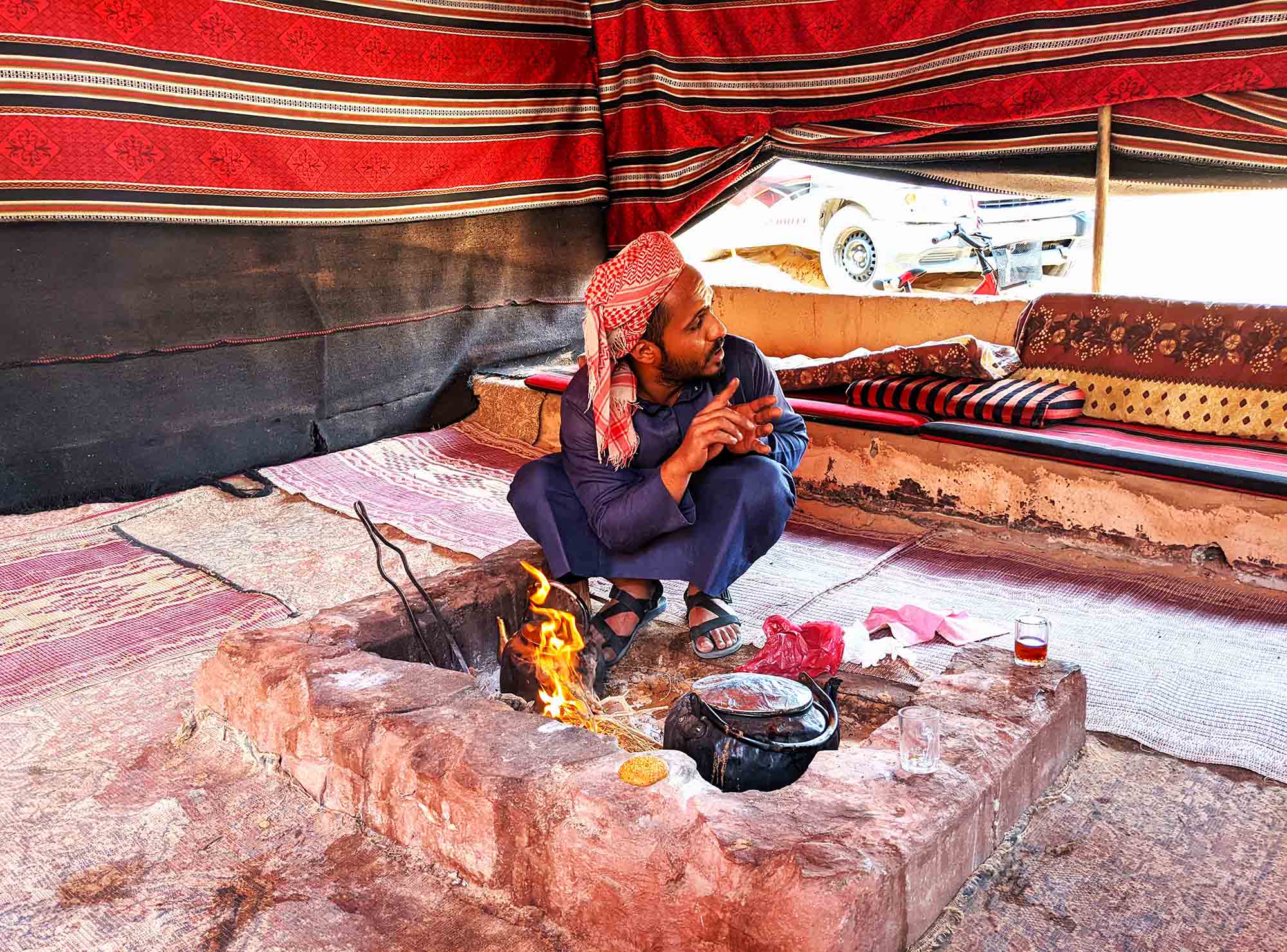 Bedouin man making tea over an open fire in the deserts of Wadi Rum, Jordan