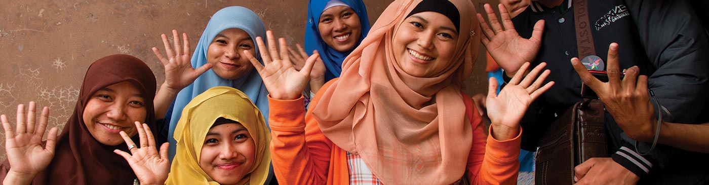 Young indonesian women waving at camera