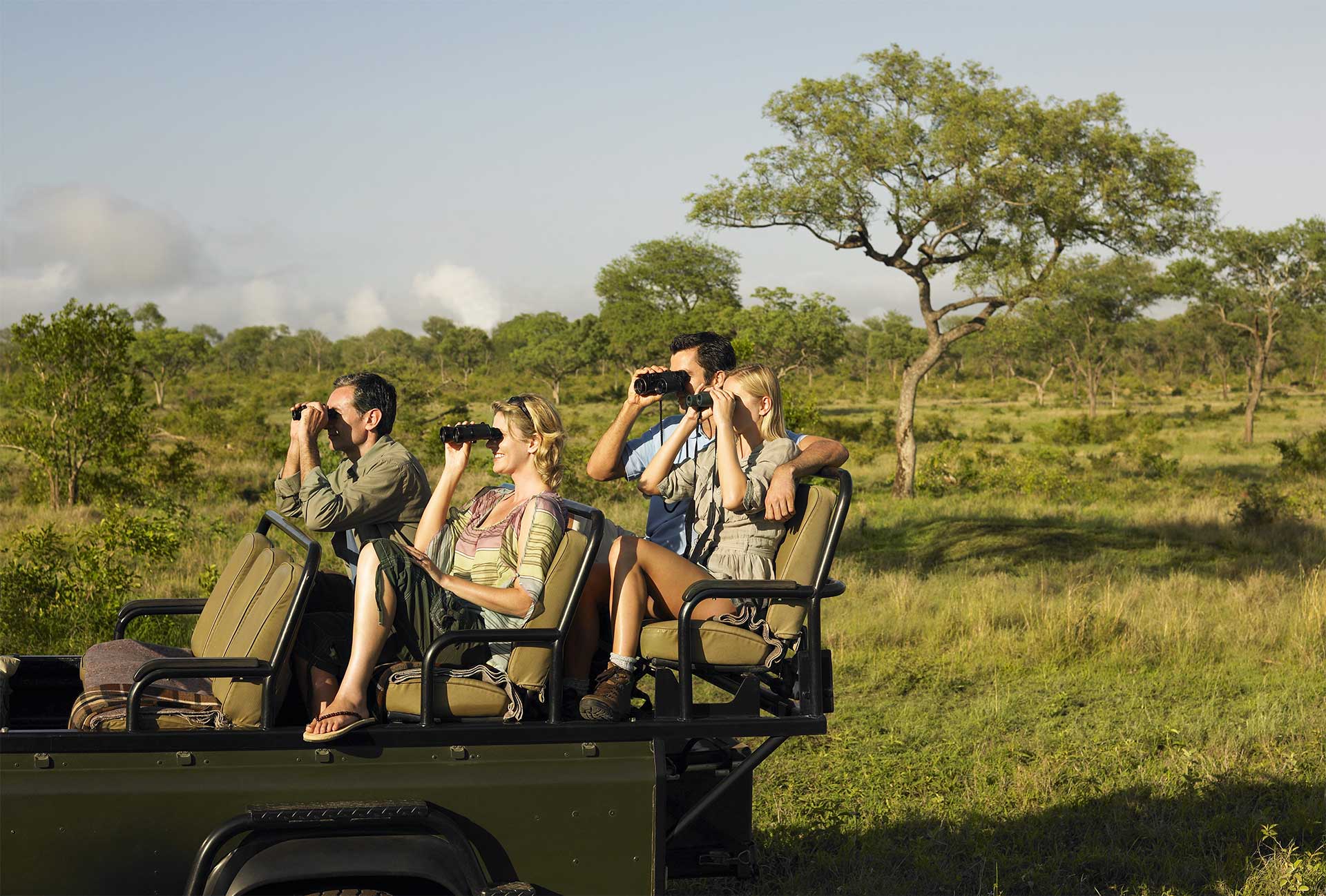Tourists viewing game from an open safari vehicle