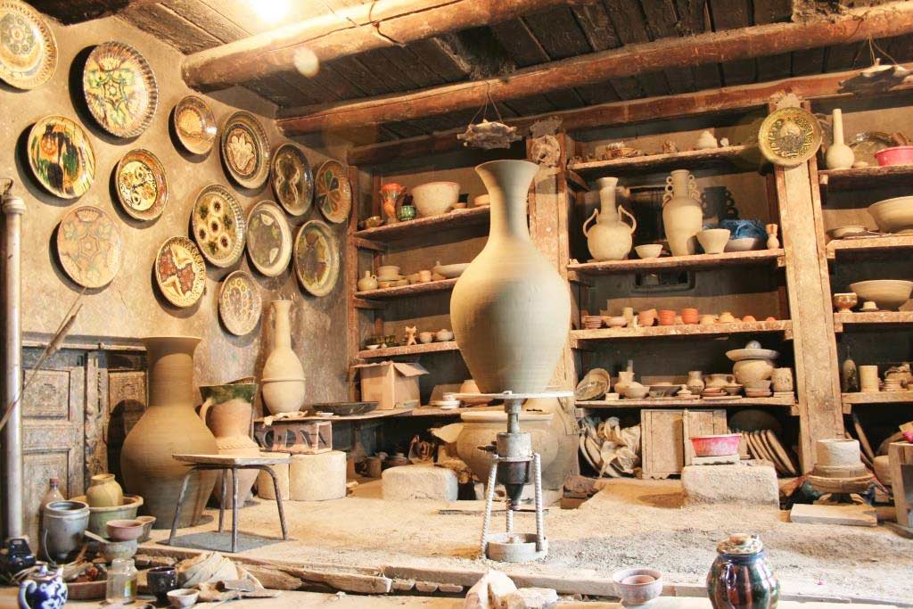 Many different pottery standing on the shelves in a pottery workshop in Uzbekistan