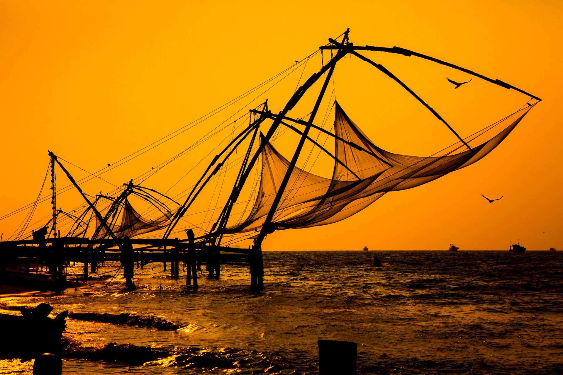 Sunset over Chinese Fishing nets and boat in Cochin (Kochi), Kerala, India