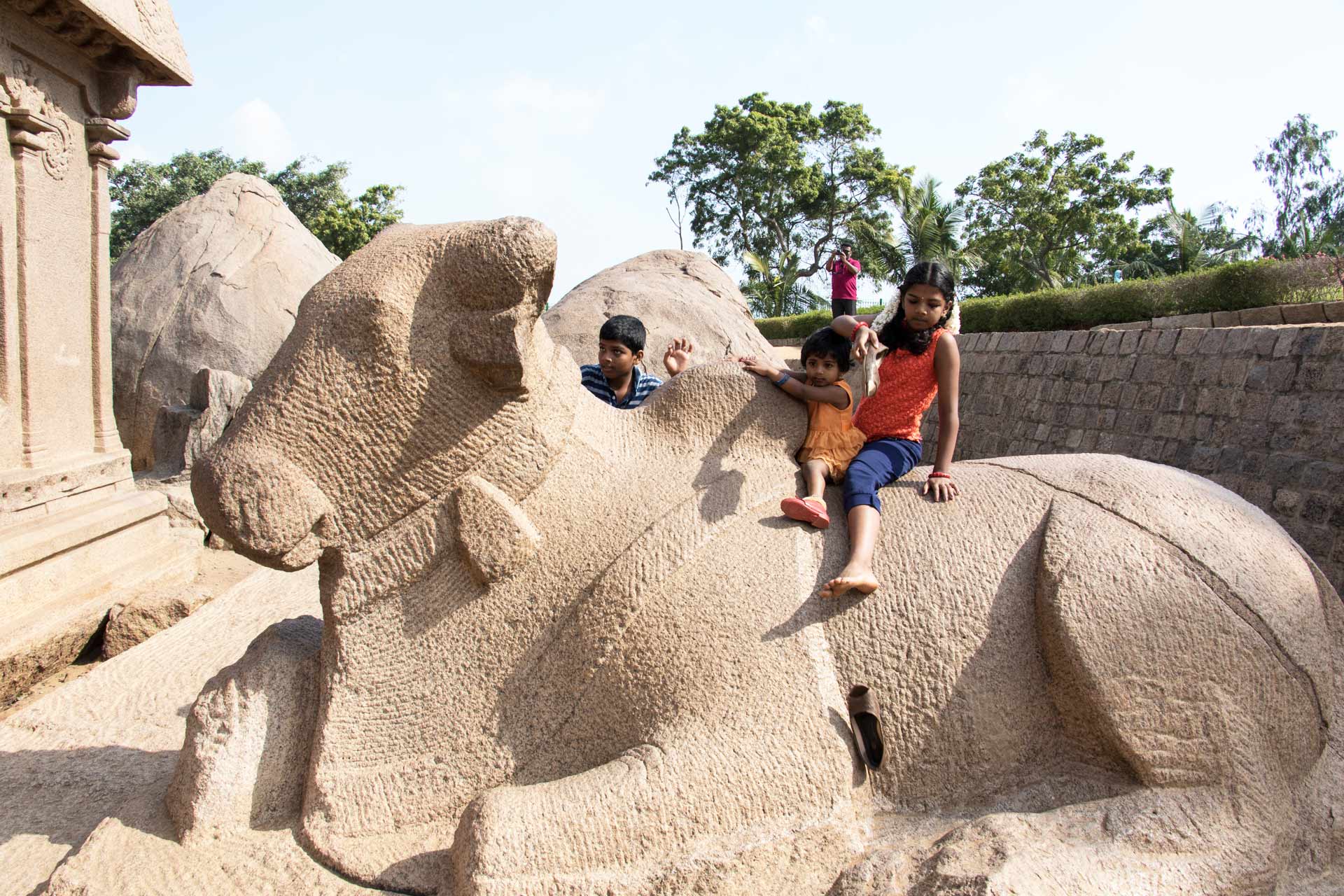 Children on a Nandi sculpture next to Draupadi's Ratha at Pancha Pandava Rathas, Mahabalipuram, Tamil Nadu, India
