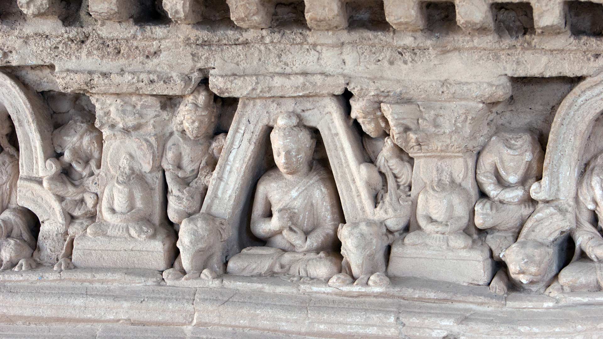 Detail of a sitting Buddha surrounded by Corinthian columns in a votive stupa in the lower stupa court of Jaulian, Taxila, Punjab, Pakistan