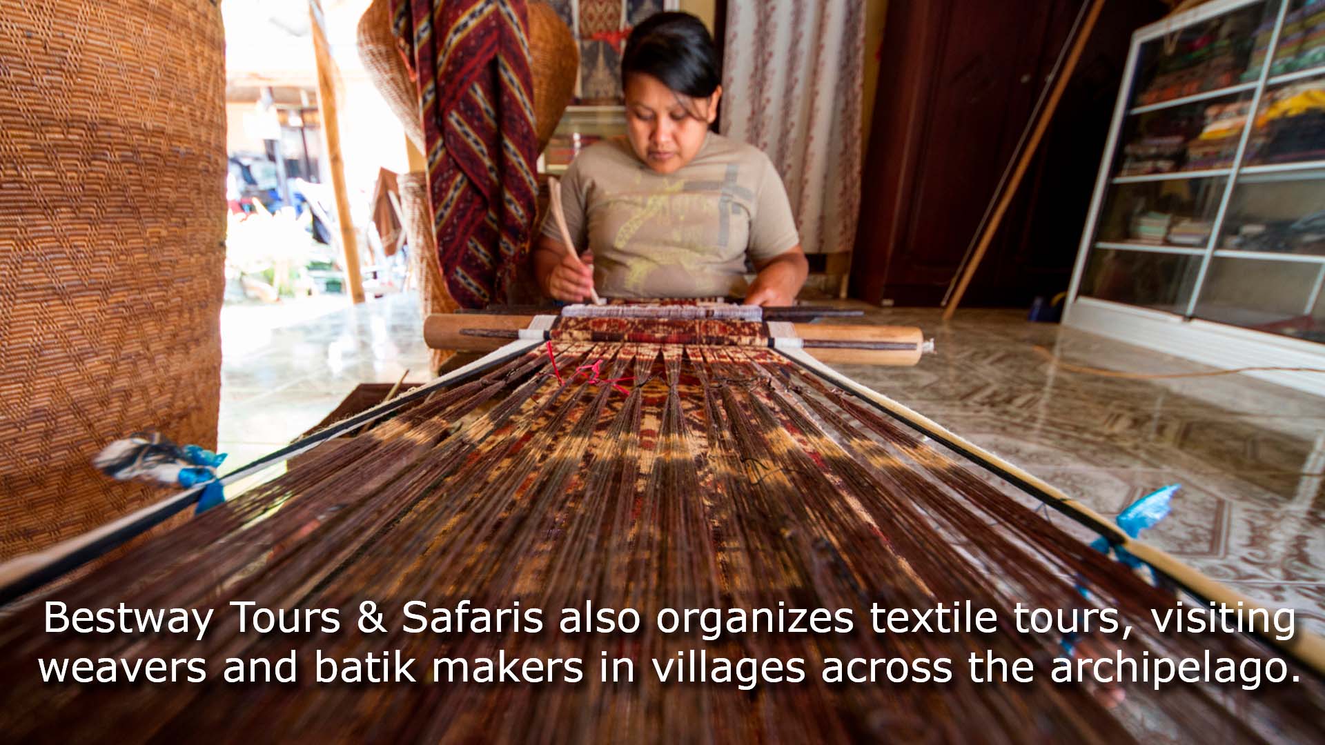 Craftswoman drawing intricate patterns by using a pen-like instrument, called canting, to apply hot wax to a fabric in the production of batik at Sarwidi's Batik workshop, Indonesia